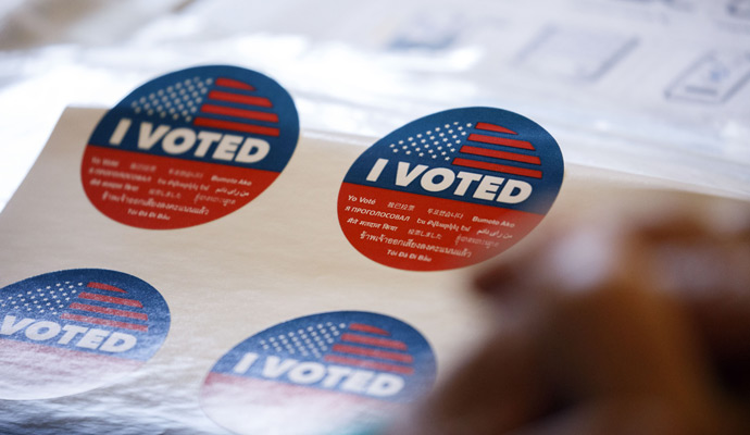 A sheet of red, white, and blue “I Voted” stickers at a polling station.  A sheet of red, white, and blue “I Voted” stickers at a polling station.