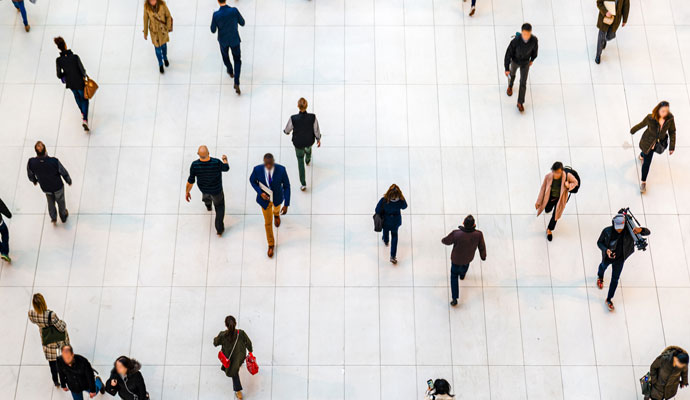 A crowd of businesspeople, commuters, and others mix and move past one another. A crowd of businesspeople, commuters, and others mix and move past one another.