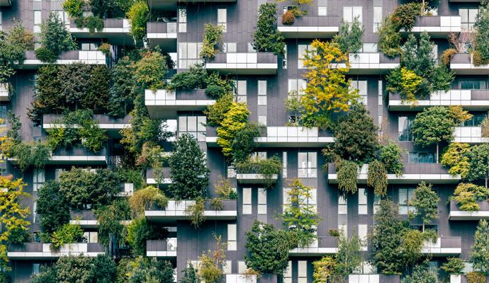 Green plants and trees grow on the balconies and exterior of a residential apartment building Green plants and trees grow on the balconies and exterior of a residential apartment building