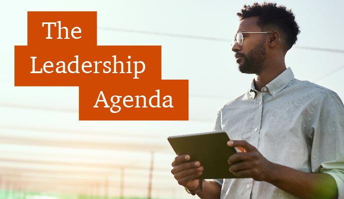 A photograph of a man with a tablet with the words "The Leadership Agenda" superimposed