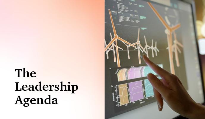 Photograph of a person's hand and a monitor  with the words "The Leadership Agenda" superimposed