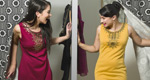 Two women emerge from neighboring fitting rooms and happily discover they are wearing the same dress