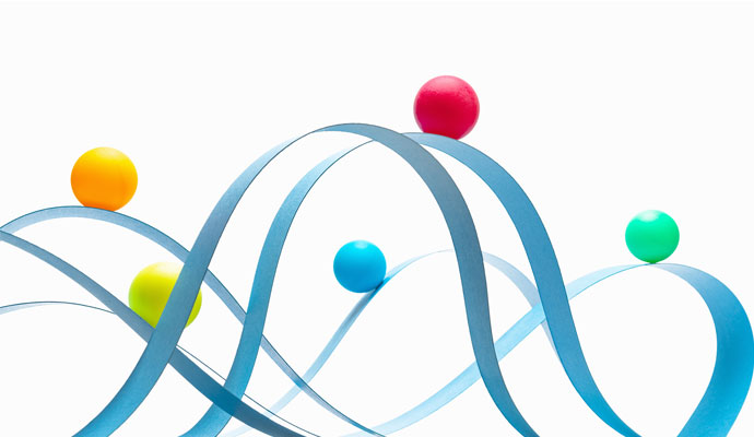 Spheres of different colors ride on waves of blue paper. Spheres of different colors ride on waves of blue paper.