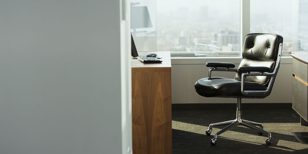 A corner office in a glass-walled building sits empty. A corner office in a glass-walled building sits empty.