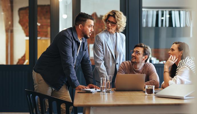 A group of businesspeople meet in an informal setting to discuss work A group of businesspeople meet in an informal setting to discuss work
