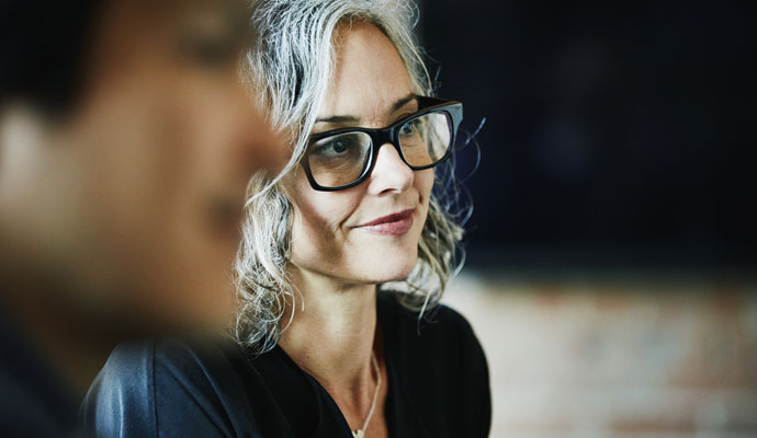 A businesswoman listens to a presentation during a team meeting. A businesswoman listens to a presentation during a team meeting.
