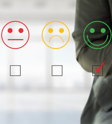 Torso and hands of a man using a smartphone. To his left is an overlay of the image on his screen: a rating system for customer service with a frowning face, a neutral face, and a smiling face. The smiling face is selected.