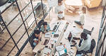 An aerial photograph of office workers collaborating in a conference room.