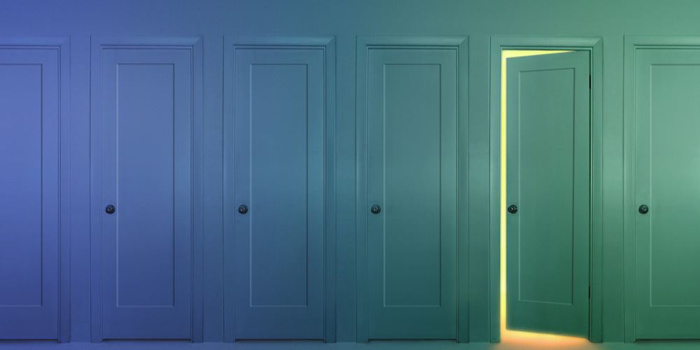 A photograph of five closed doors and one door that is opening a crack to show a bright light shining behind it. A photograph of five closed doors and one door that is opening a crack to show a bright light shining behind it.