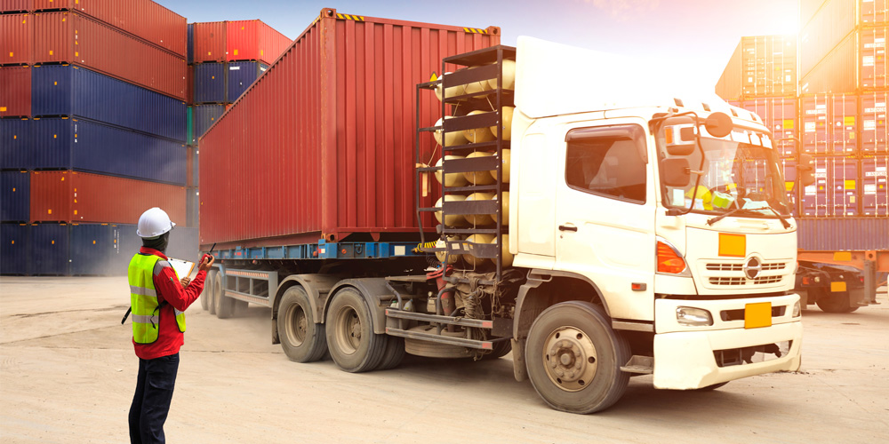 Foreman checks a tractor trailer in a busy container depot Foreman checks a tractor trailer in a busy container depot