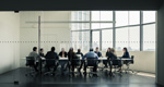A team of businesspeople convenes around a conference table.