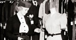 1930s woman checking price of a dress in a department store