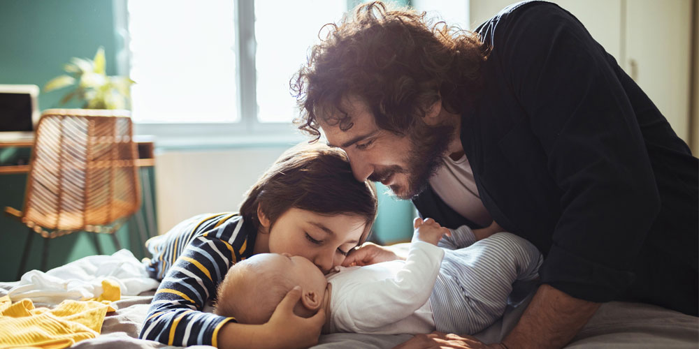 A father snuggles with his children at home A father snuggles with his children at home