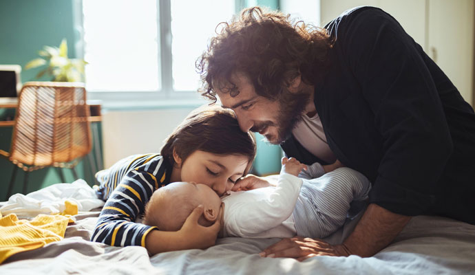 A father snuggles with his children at home A father snuggles with his children at home