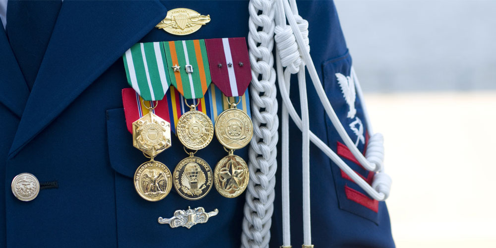 Military medals decorate a uniform jacket. Military medals decorate a uniform jacket.