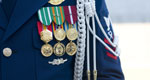 Military medals decorate a uniform jacket.