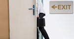 Businessperson walking out of an office, briefcase in hand