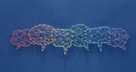 A network of pins and threads forms the shape of interconnecting speech bubbles, representing inclusion.