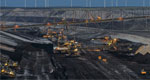 A photo of bucket-chain excavators in a lignite mine with wind turbines in the background in Cottbus, Germany