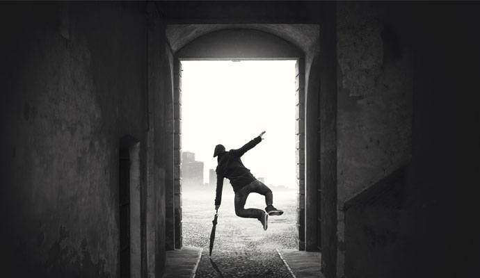 A photograph of a man with an umbrella kicking his heels together on a rainy day. A photograph of a man with an umbrella kicking his heels together on a rainy day.