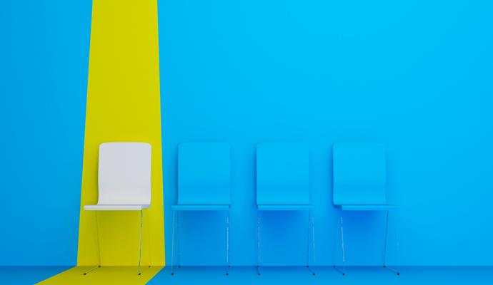 In a row of blue chairs set against a blue background, a white chair is highlighted by a bright, yellow stripe. 