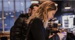 Woman using a mobile app to pay in a coffee shop 