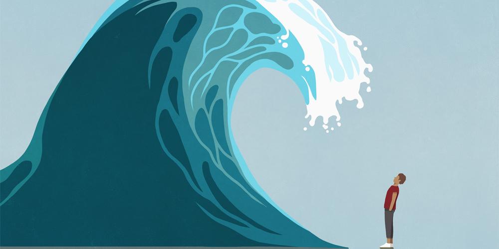 An illustration of a man standing before a giant wave that’s about to crash over him. An illustration of a man standing before a giant wave that’s about to crash over him.