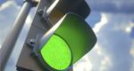 A closeup photograph of a green traffic light	