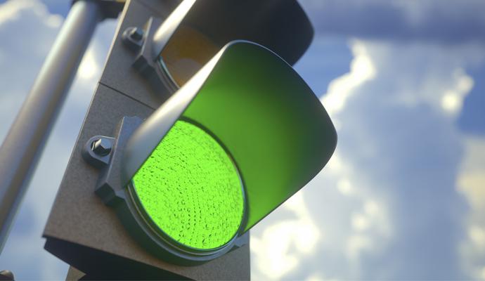 A closeup photograph of a green traffic light	