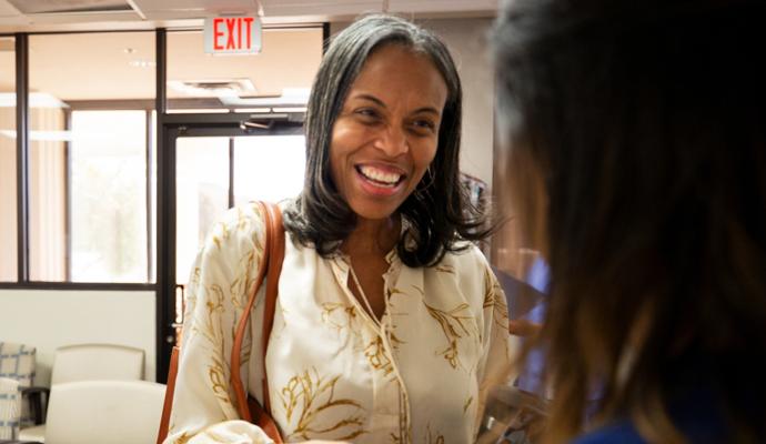 A photograph of a smiling patient being admitted to a doctor’s office