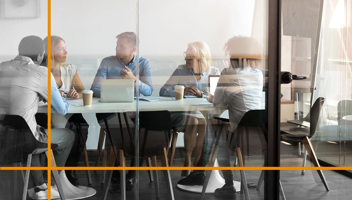 Five colleagues meet and collaborate around a table in a glass-walled conference room Five colleagues meet and collaborate around a table in a glass-walled conference room