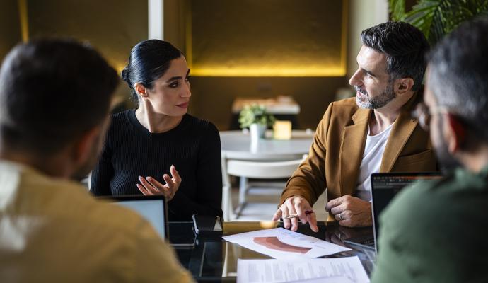 At an informal meeting, a businesswoman leads a discussion with three colleagues. At an informal meeting, a businesswoman leads a discussion with three colleagues.