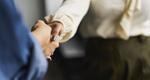 Photo of two women shaking hands in a conference room