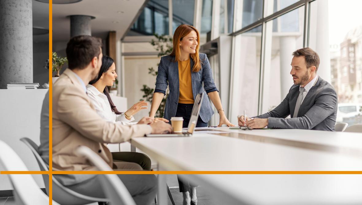Female manager standing at corporate office with her leadership team and discussing business plan. Female manager standing at corporate office with her leadership team and discussing business plan.