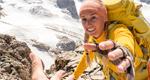 A female mountain climber reaches for a helping hand 