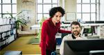 Manager assisting an employee working on a computer.