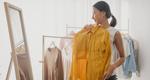 Woman choosing clothes on clothes rack, looking at herself in a mirror