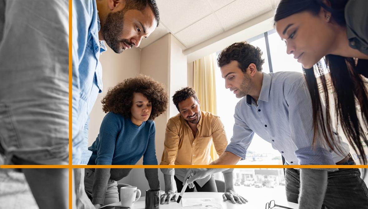 A team of colleagues gathers around a table to discuss the data in a printed report.