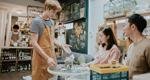 Happy employee giving advice to couple in zero-waste store