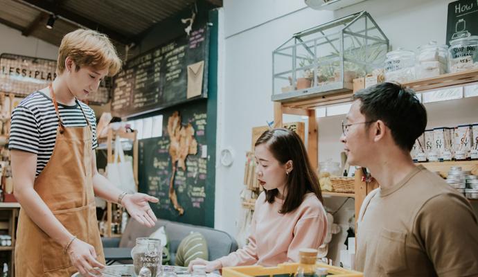 Happy employee giving advice to couple in zero-waste store