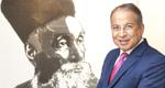 Dr. Praveer Sinha seen in a blue suit next to a pen-and-ink portrait of the founder of Tata Power, Jamsetji Tata