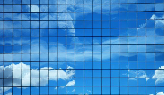Sky and clouds reflected in a modern skyscraper's glass facade. Sky and clouds reflected in a modern skyscraper's glass facade.