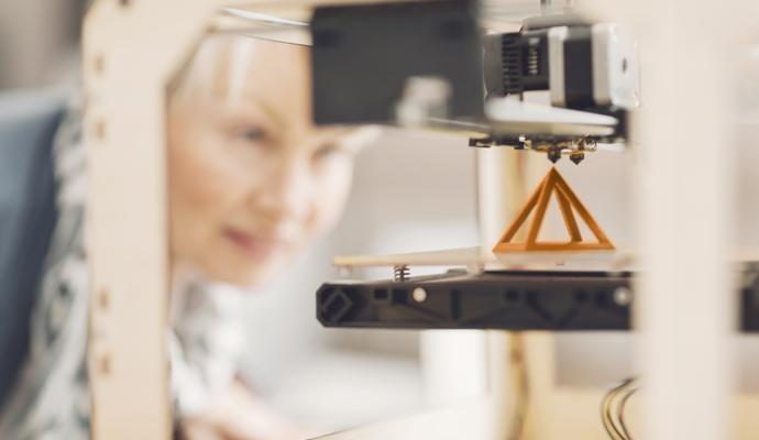 Photograph of a woman looking at a small 3D-printed pyramid Photograph of a woman looking at a small 3D-printed pyramid