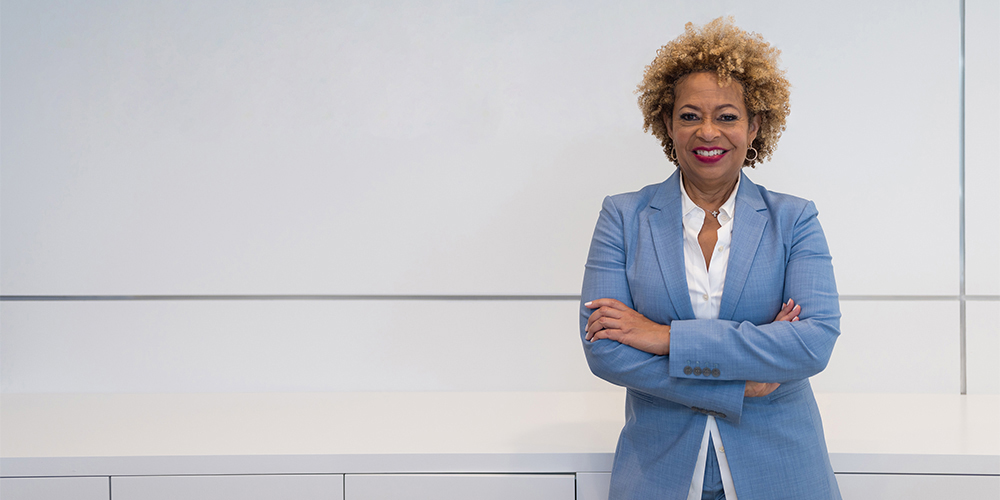 Deryl McKissack stands in front of a white wall, smiling with her arms folded. Deryl McKissack stands in front of a white wall, smiling with her arms folded.