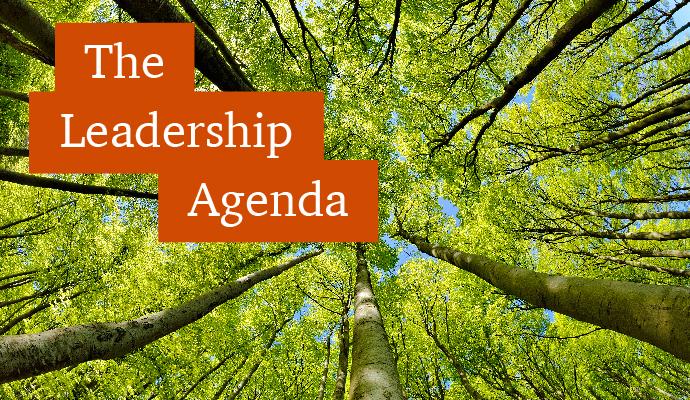 A photograph taken from the ground looking up at a canopy of trees with the words "The Leadership Agenda" superimposed