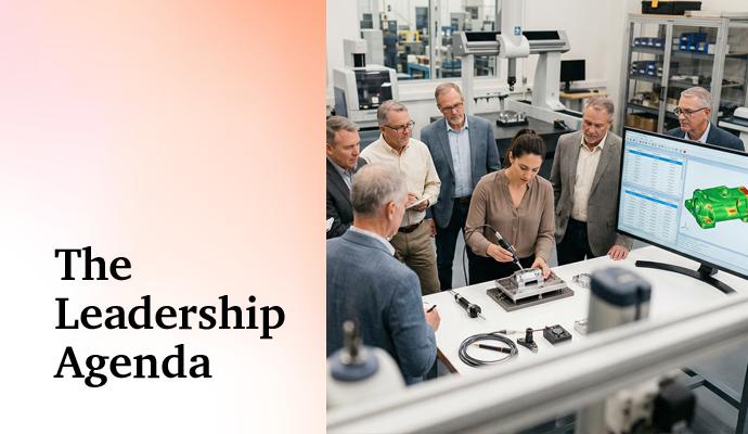 A group of professionals stands around a workstation and reviews equipment in a laboratory.