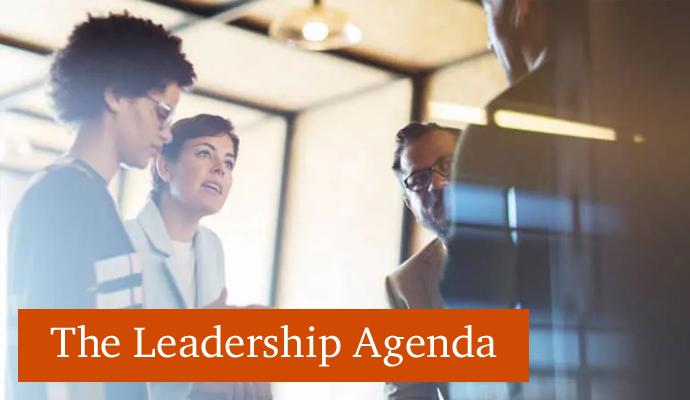 Photograph of a group of coworkers talking with the words "The Leadership Agenda" superimposed