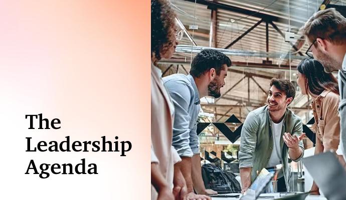 Group of coworkers gathered around a table, discussing a project in a modern workspace.