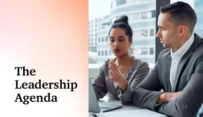 Photograph of a group of office workers looking at a laptop with the words "The Leadership Agenda" superimposed