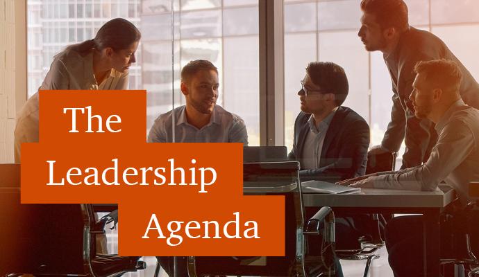 Photograph of a group of office workers around a table with the words "The Leadership Agenda" superimposed